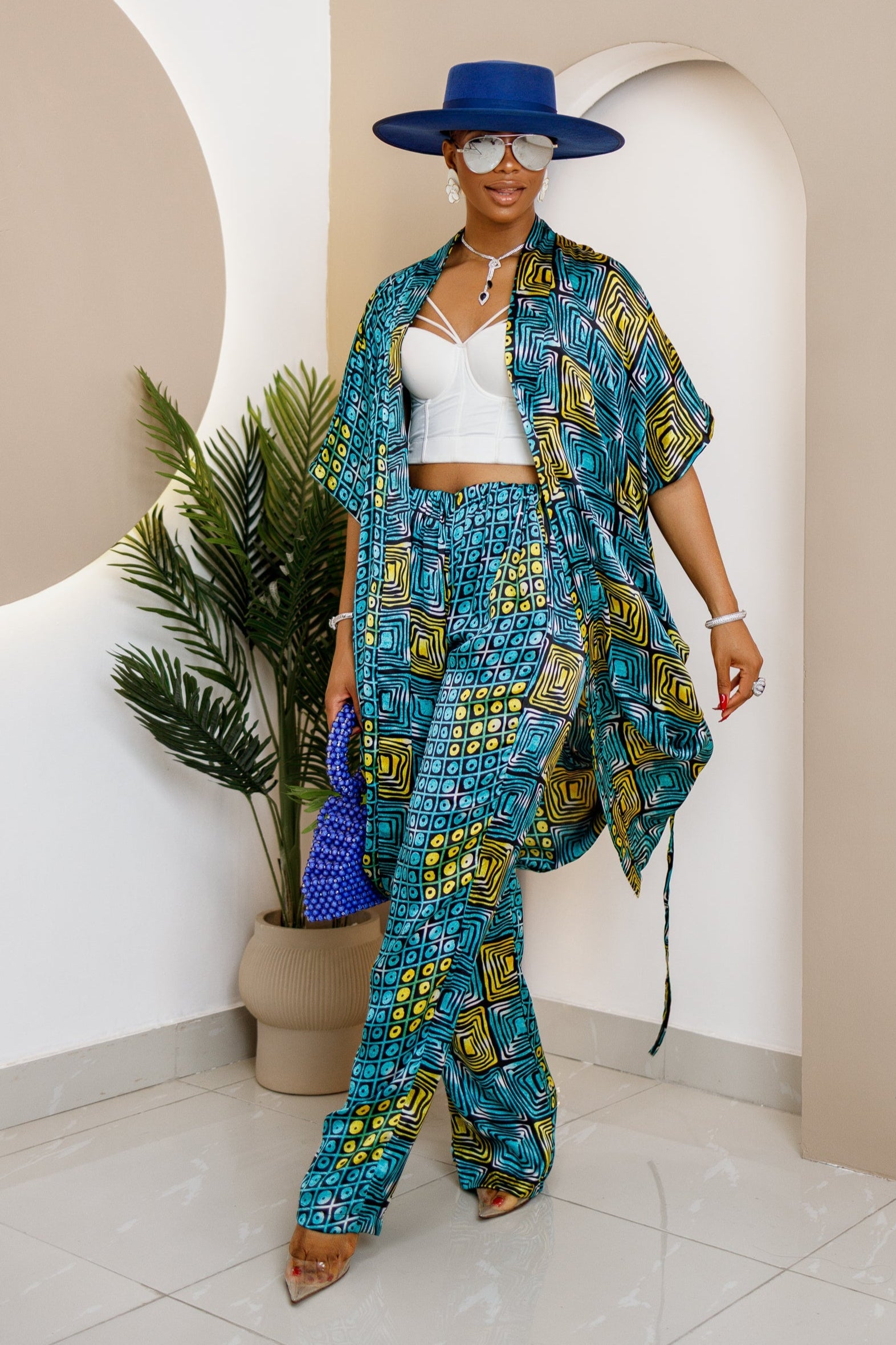 Woman wearing a vibrant blue and yellow Ankara print co-ord set with a kimono, trousers.