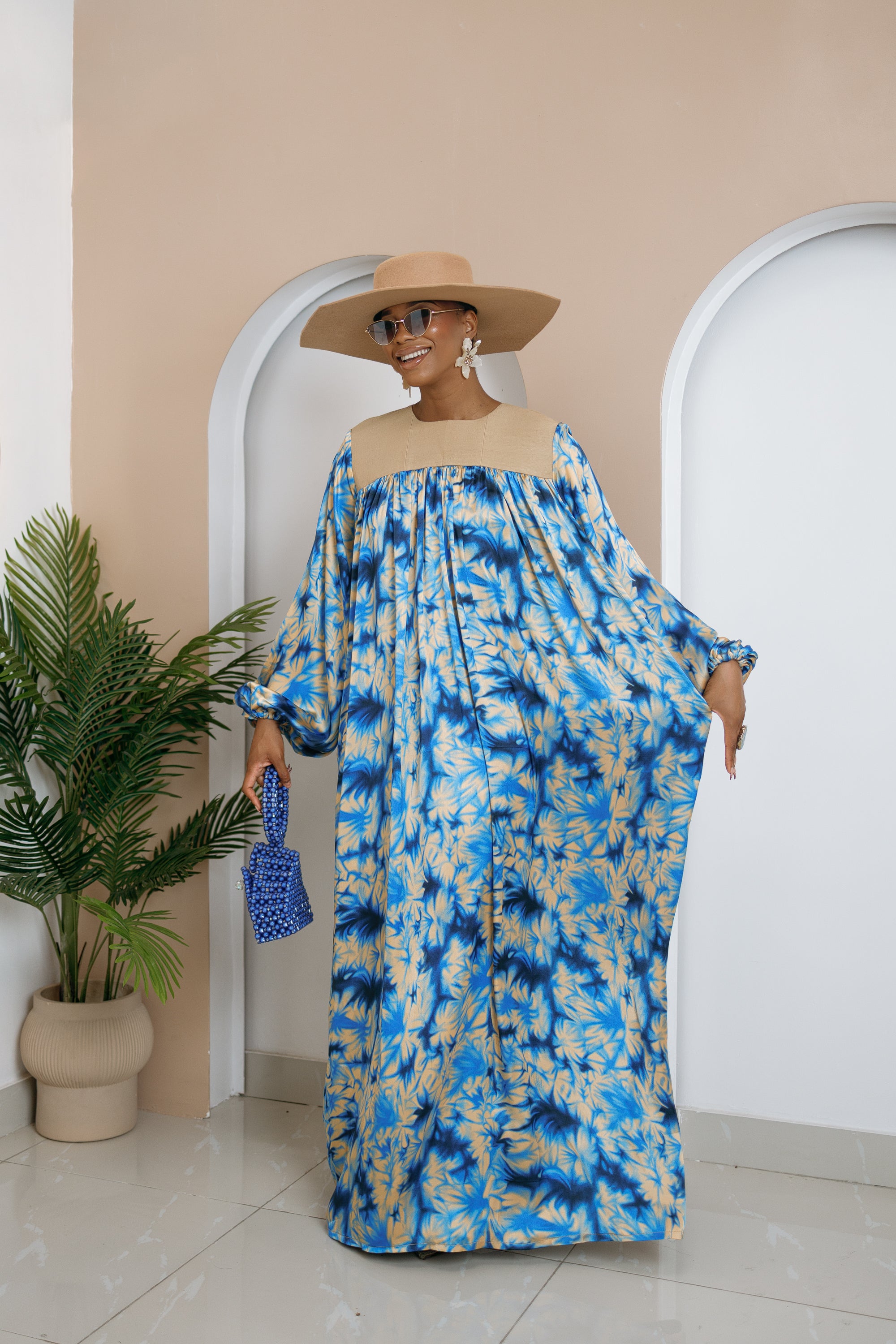 Model wearing Chikosolu floor-length silk and Aso Oke dress with yoke design, flowy sleeves, and side pockets.