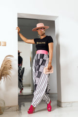 A woman posing in black and white African Print parachute pants.