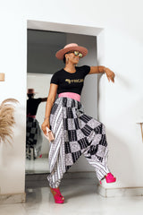 A woman posing in black and white African Print parachute pants.