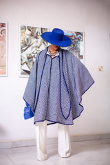A woman posing in a blue and white African Print cape.