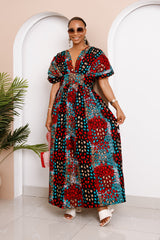 Model wearing Obidia Ankara Maxi Dress with puff sleeves and geometric red, teal, and black patterns