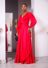 A woman posing in a red maxi dress with ruffles.