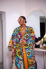 A woman posing in a multicolored African Print kimono.