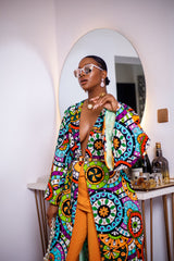 A woman posing in a multicolored African Print kimono.