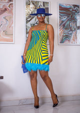A woman posing in a blue and yellow African print mini dress.
