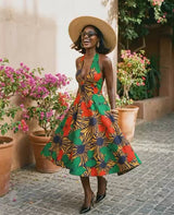 Umueze Ankara fit-and-flare midi dress featuring a deep V-neck halter neckline, open back with tie-neck detail, side pockets, and a full mid-calf skirt.